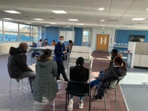 People sit in a room being trained to be vaccination volunteers